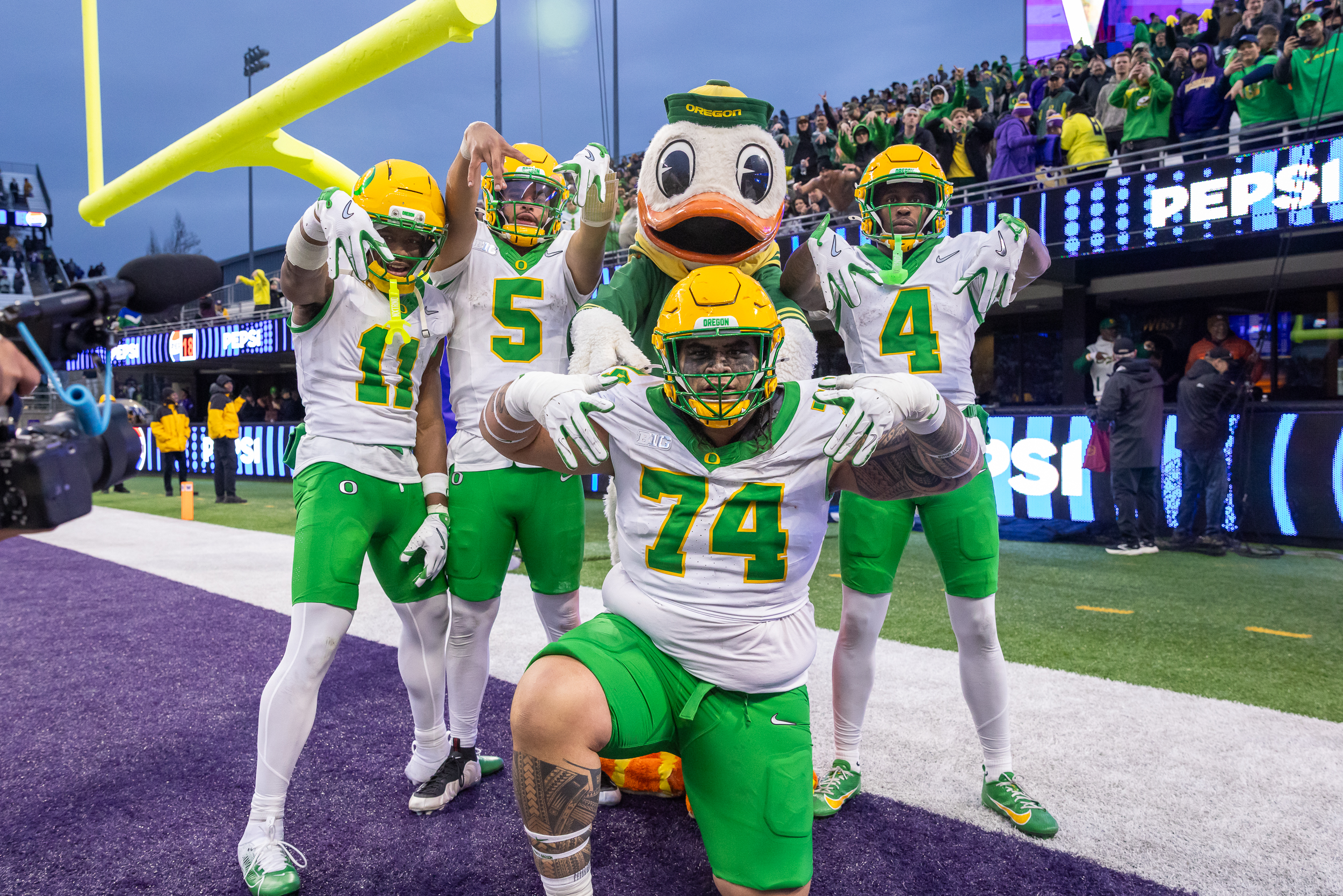 Oregon players and Duck mascot celebrate in Husky Stadium end zone
